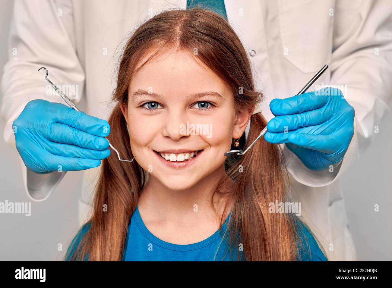 Fille positive en clinique dentaire pour les enfants. Enfant avec un sourire Toothy lors de l'inspection de la cavité buccale par un dentiste. Gros plan Banque D'Images
