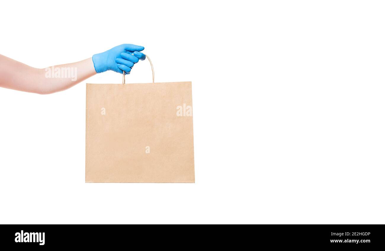 emballage écologique en papier marron pour tenir la main du livreur dans un gant stérile isolé sur un fond blanc bannière avec espace de copie, livraison sûre pendant Banque D'Images