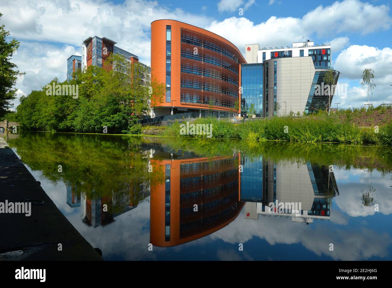 Les bâtiments de l'Université de Montfort se reflètent dans le canal de Grand Union À Leicester Banque D'Images