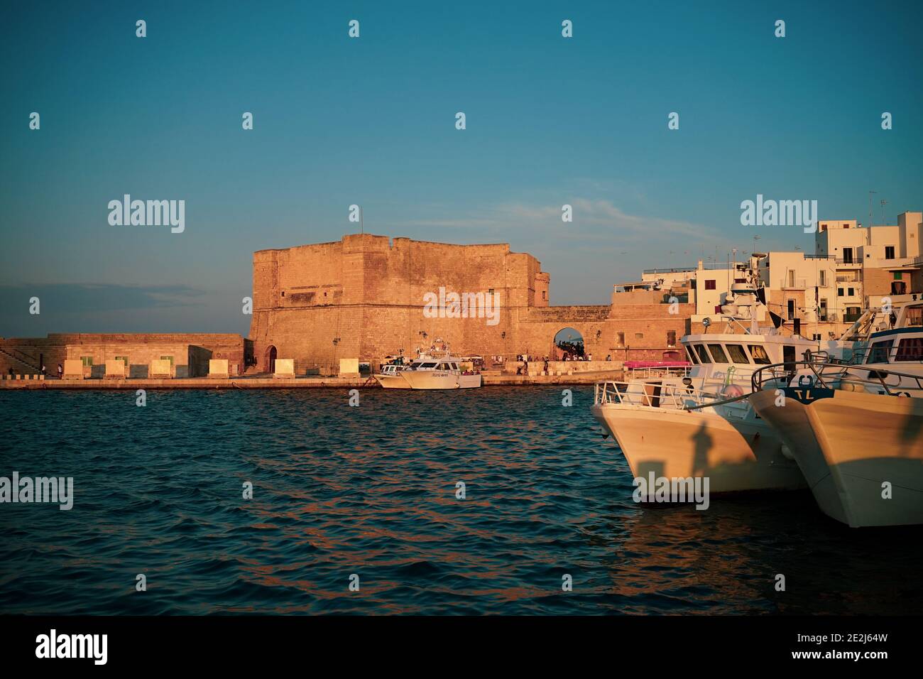 Des bateaux amarrés à Canal par des bâtiments de la ville au coucher du soleil. Banque D'Images