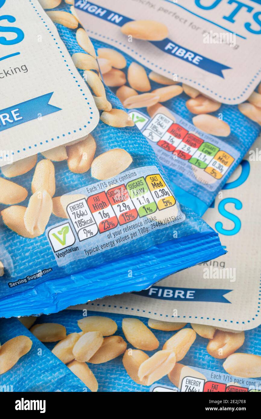Gros plan des boîtes d'information nutritionnelle avec code couleur sur l'avant des arachides salées ASDA emballées en plastique. Graisses alimentaires / graisses dans l'étiquetage des aliments. Banque D'Images