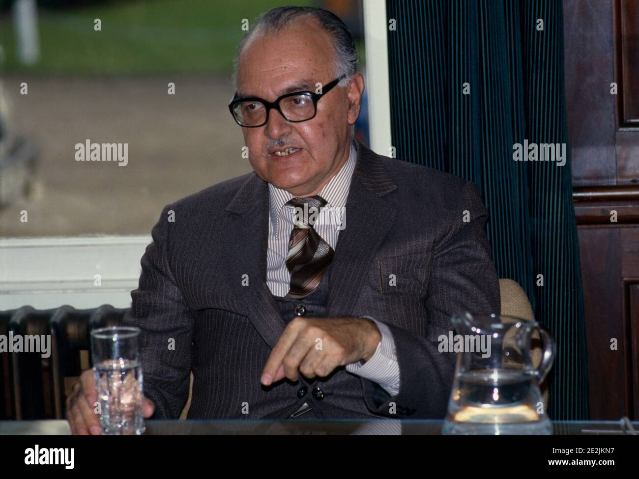 Un homme d'affaires plus âgé insiste sur un point lors d'une réunion Banque D'Images