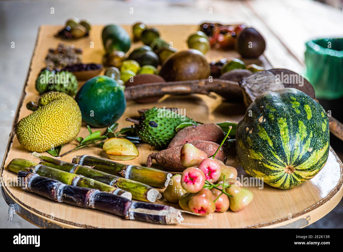 Une table du Belmont Estate, Hermitage, Saint Patrick, Grenade, présente une sélection de produits cultivés sur le domaine : jacquier, un fruit épineux vert (Annona muricata), patates douces, canne à sucre, fruits de pomerac roses (pomme malaisienne) et une courge rayée vert et jaune. Banque D'Images