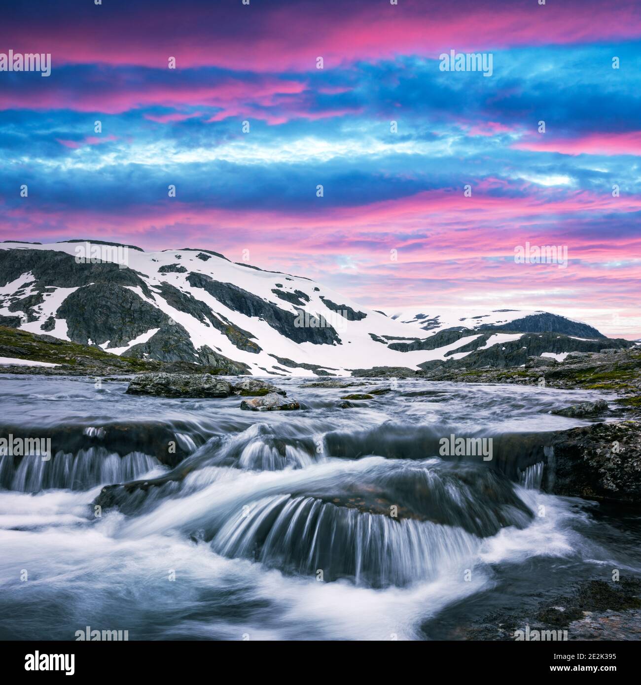 Lever de soleil coloré sur les montagnes norvégiennes enneigées et rivière claire près de la célèbre Aurlandsvegen (Bjorgavegen), route de montagne, Aurland, Norvège. Banque D'Images
