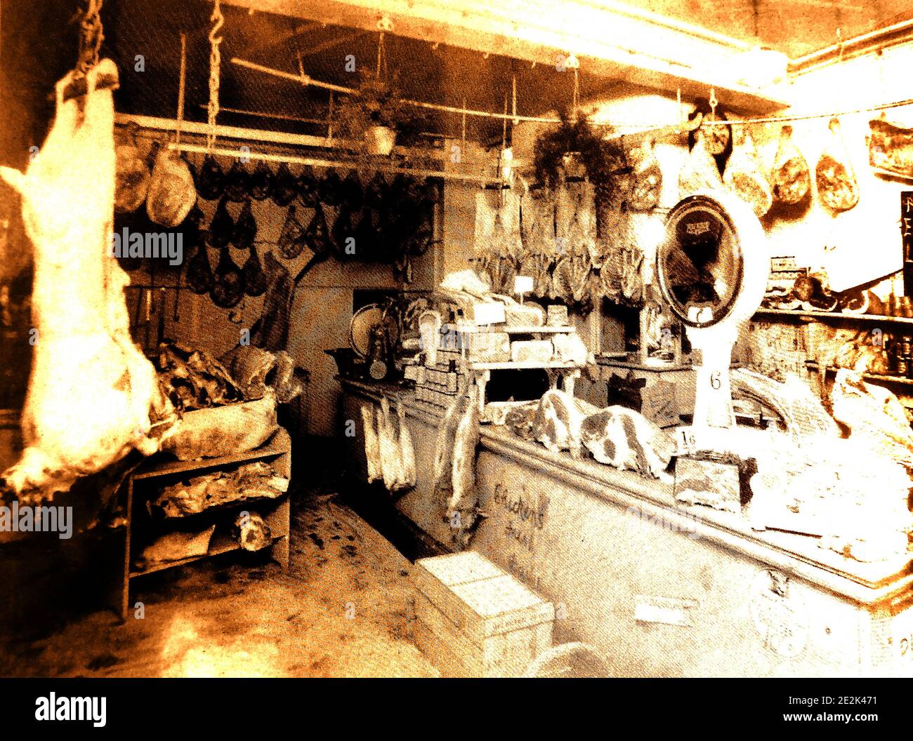 Une photo ancienne de l'intérieur d'un boucherie traditionnel à Whitby, dans le North Yorkshire, en Angleterre. La viande coupée et les carcasses sont exposées en plein air, comme c'était la pratique générale. Une vieille balance à viande est visible sur le comptoir. Banque D'Images