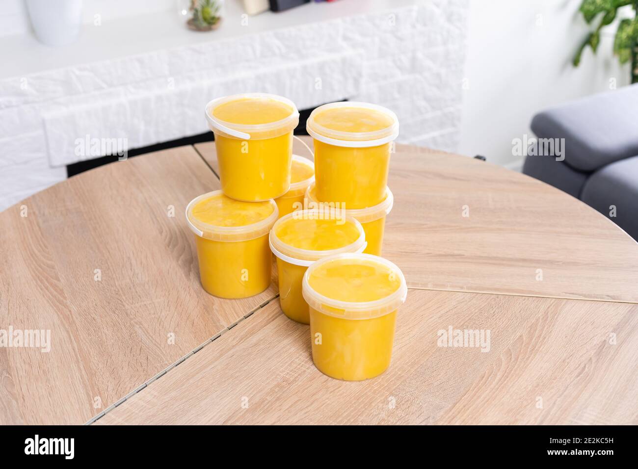 seaux en plastique avec miel sur une table en bois Banque D'Images