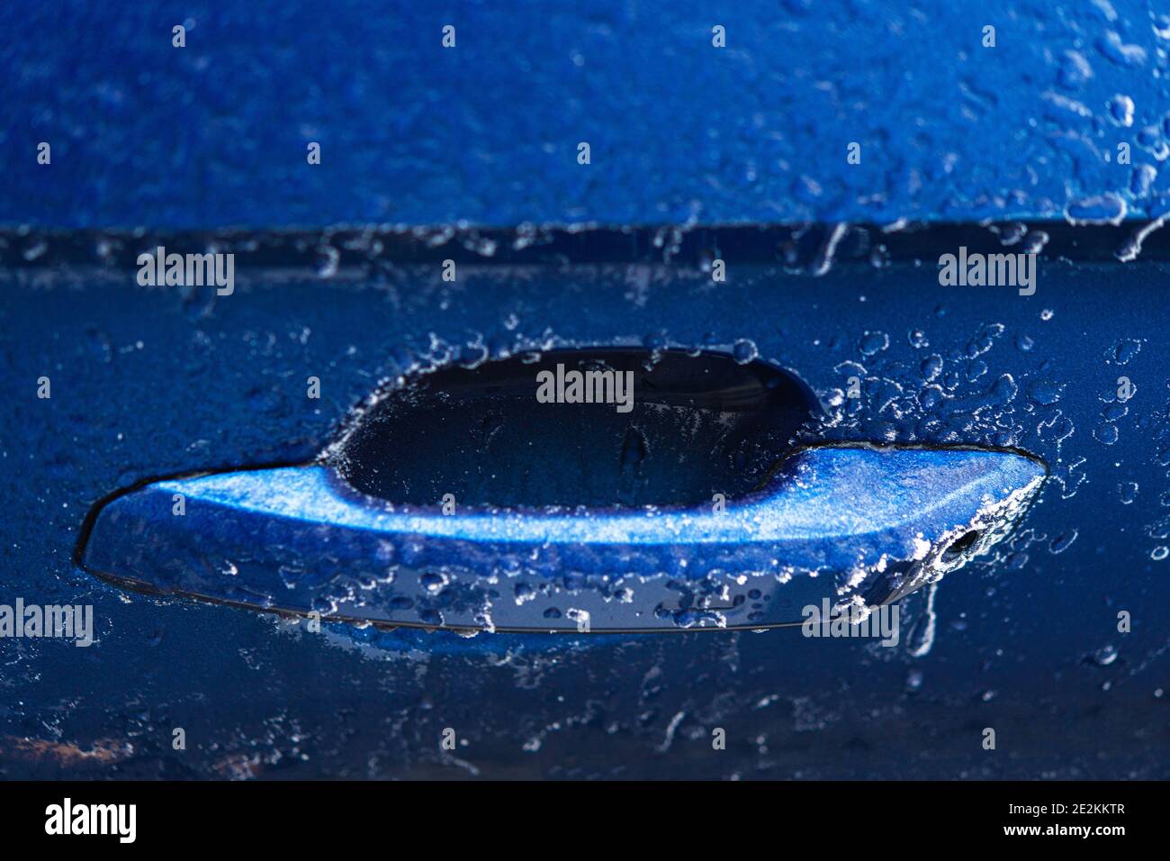 Industrie automobile. Fermeture de la poignée de porte de voiture de carrosserie bleu glacé. Thème des problèmes de véhicules météorologiques d'hiver. Banque D'Images