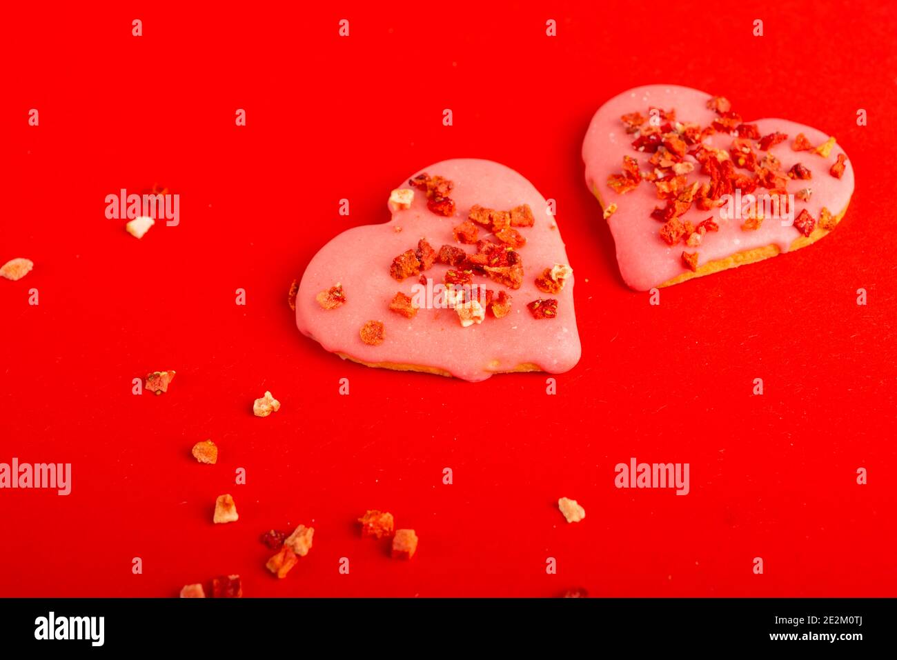 Deux biscuits coeur rouge en forme de coeur pour la Saint-Valentin sur fond rouge. Vue de dessus. Espace pour le texte. Gâteries Banque D'Images