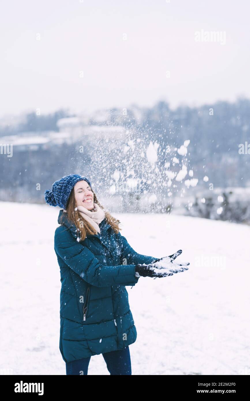 Jeune jolie femme jouant avec la neige dans les vêtements d'hiver Banque D'Images