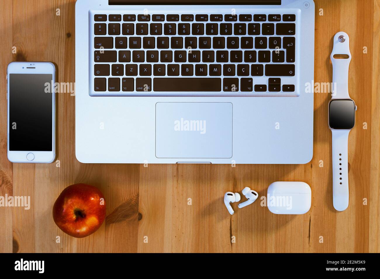 Izmir, Turquie - 29 novembre 2020 : vue de dessus des produits de la marque Apple sur fond de bois. MacBook pro, iPhone 8, airpods pro, pomme rouge et une pomme Banque D'Images