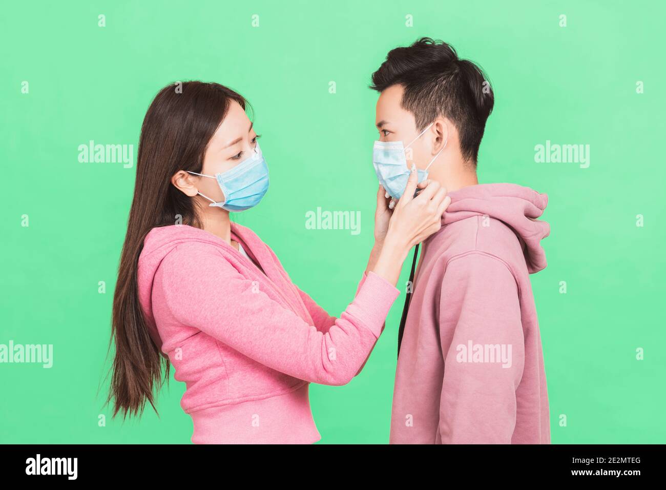 Les jeunes couples aident à porter un masque de protection Banque D'Images