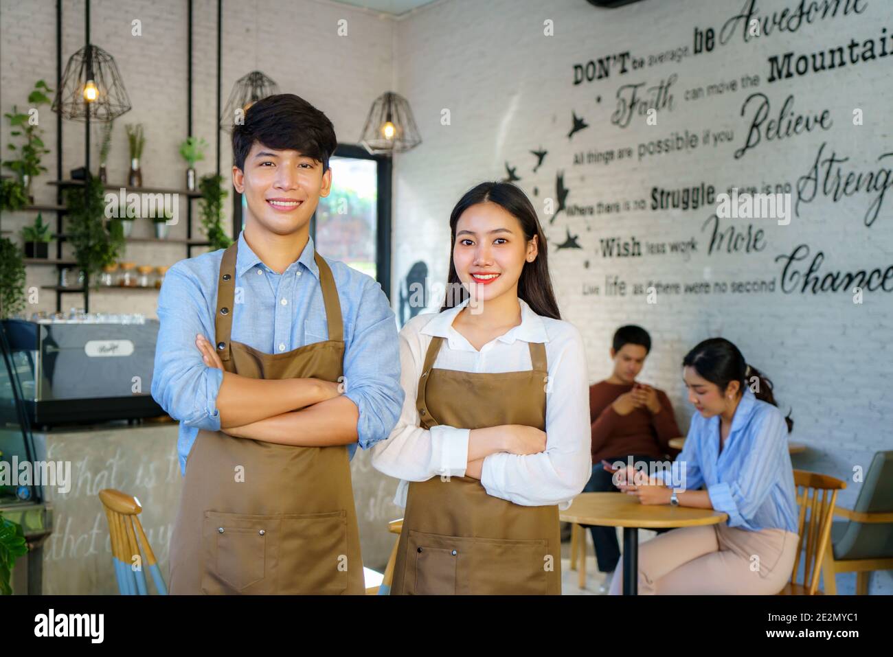 Couple asiatique Barista ou propriétaire petite entreprise dans la recherche de tablier À l'appareil photo prêt à donner le service du café au moderne café-restaurant Banque D'Images