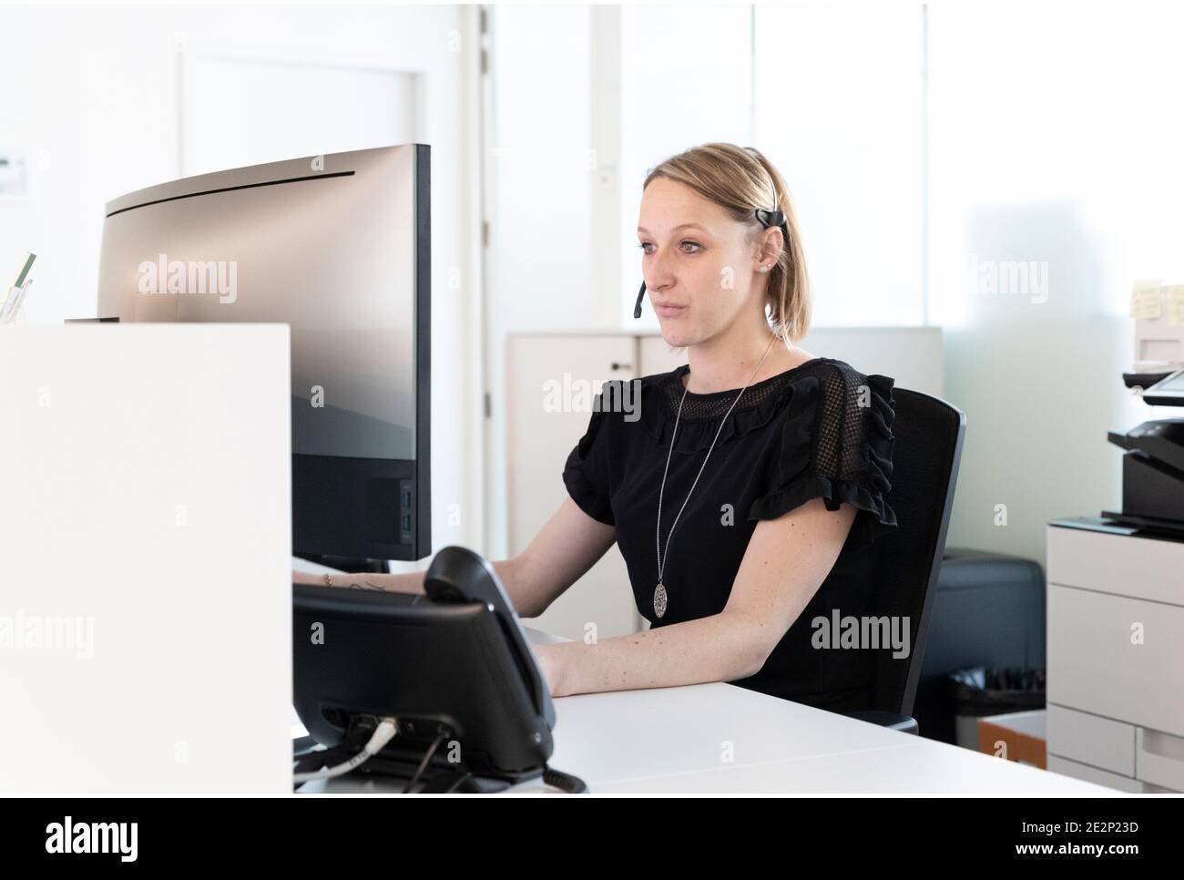 une secrétaire médicale écrit un rapport sur son ordinateur Banque D'Images
