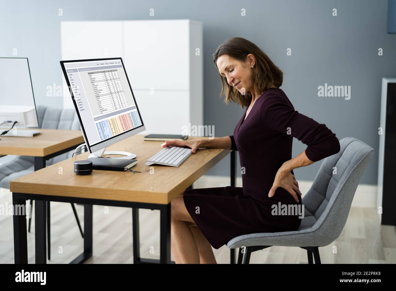 Douleurs dorsales au travail. Mauvaise posture de l'ordinateur Banque D'Images