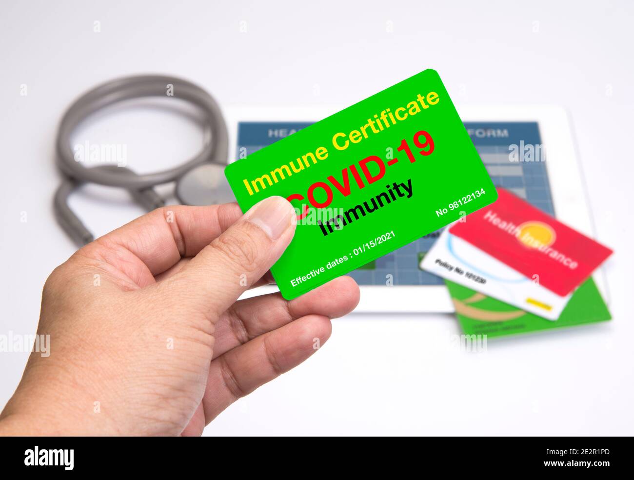 Carte de certification immunitaire Covid-19 fermée dans une main. Banque D'Images Carte de certification immunitaire Covid-19 fermée dans une main. Banque D'Images