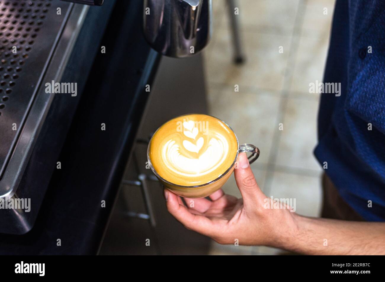 Main du barista qui prépare du café au Latte ou au Cappuccino, verse du lait pour préparer des latte Banque D'Images