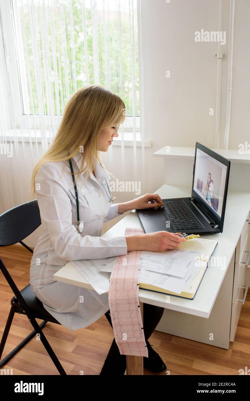 Portrait vertical médecin confiante femme médecin assise au bureau et souriante à la caméra, aux soins de santé et à la prévention concept Banque D'Images
