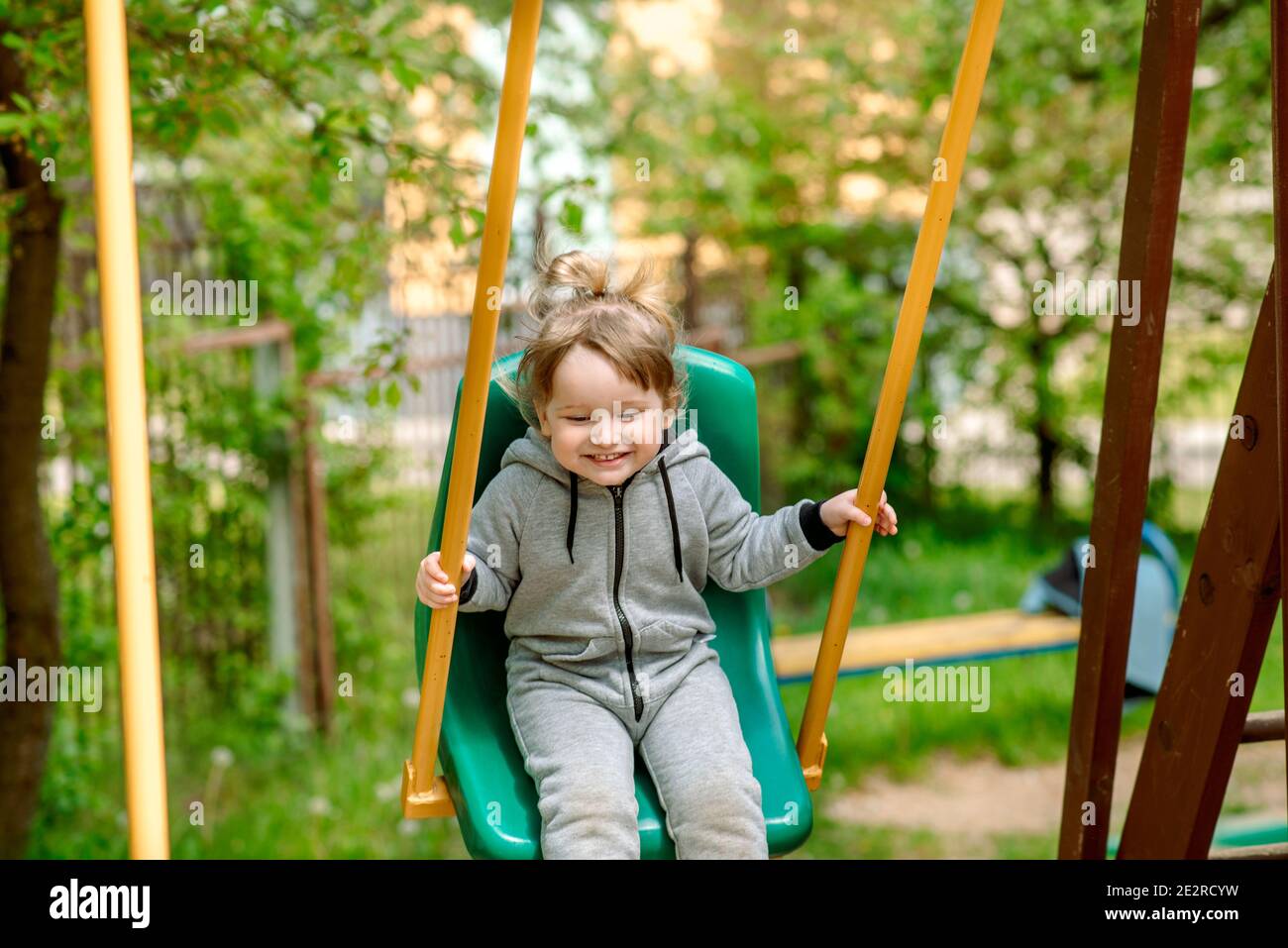 Rire de l'enfant à balancer en été park.plays jeux, courses et sauts pour enfants. Enfance insouciante. Banque D'Images