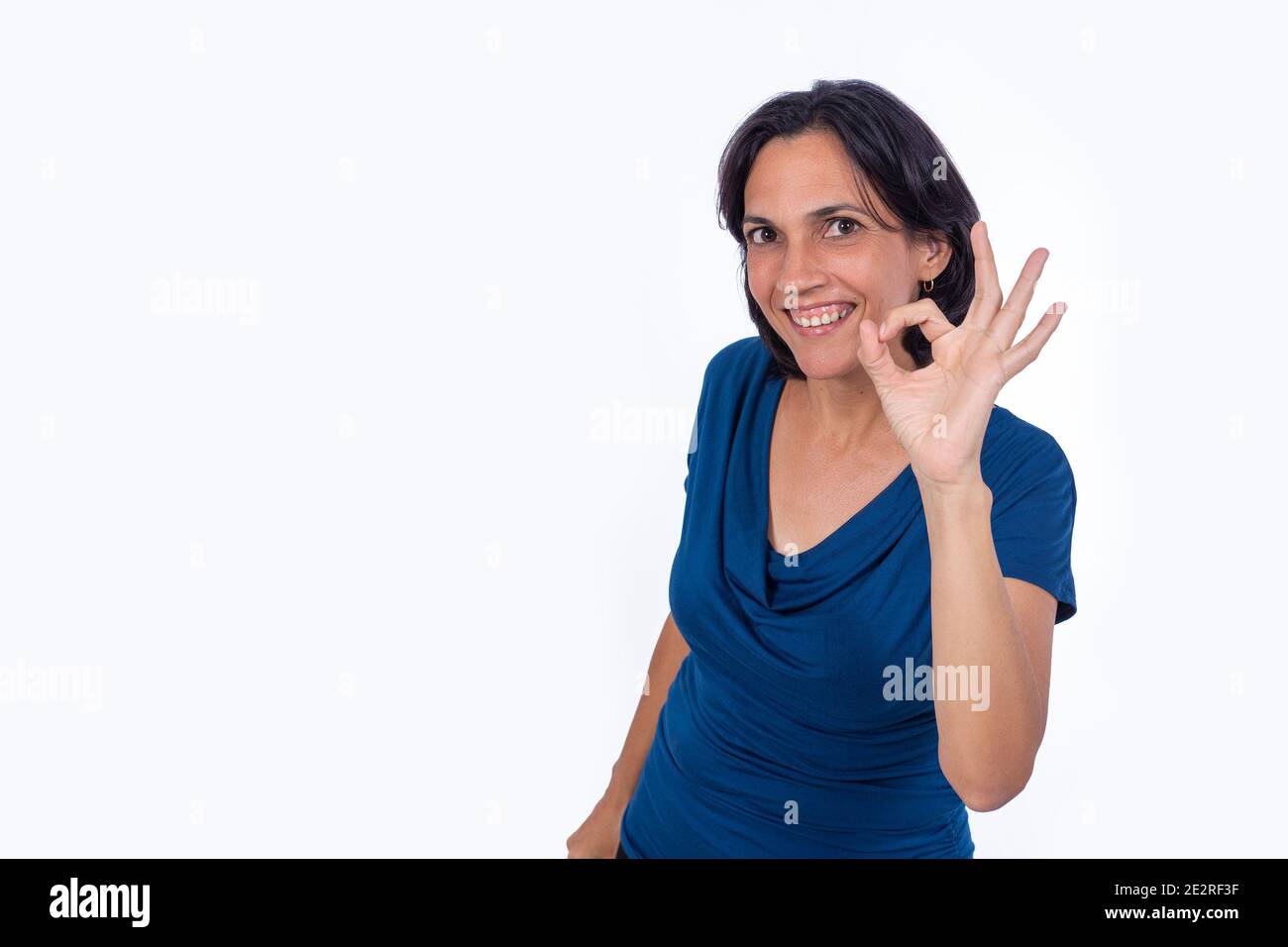 Femme souriante faisant le symbole ok avec sa main. Arrière-plan blanc Banque D'Images