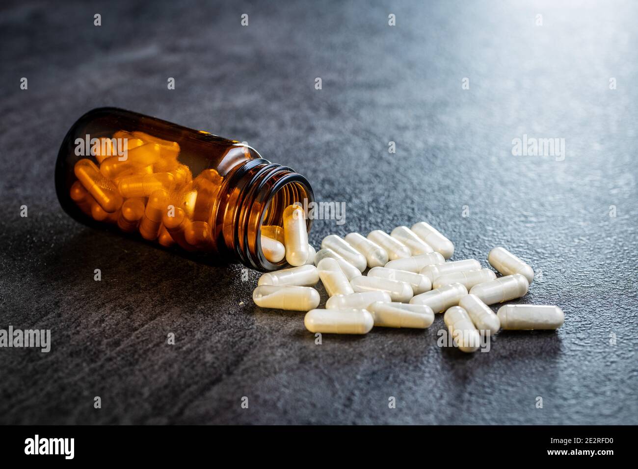 Pilules médicales blanches dans un contenant. Pilules, comprimés et capsules de médecine pharmaceutique dans un pot en verre. Banque D'Images