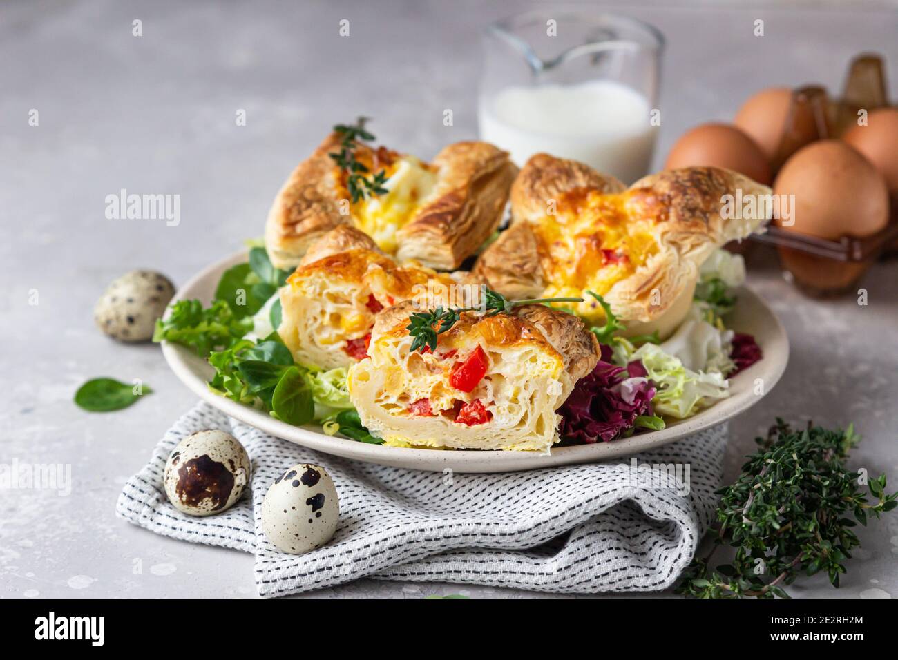 Mini quiche, tarte ou tarte avec légumes servis sur une assiette avec salade verte. Mise au point sélective. Banque D'Images