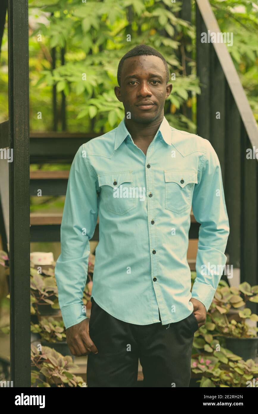 Les jeunes d'Afrique noire homme debout contre l'escalier moderne avec la nature Banque D'Images