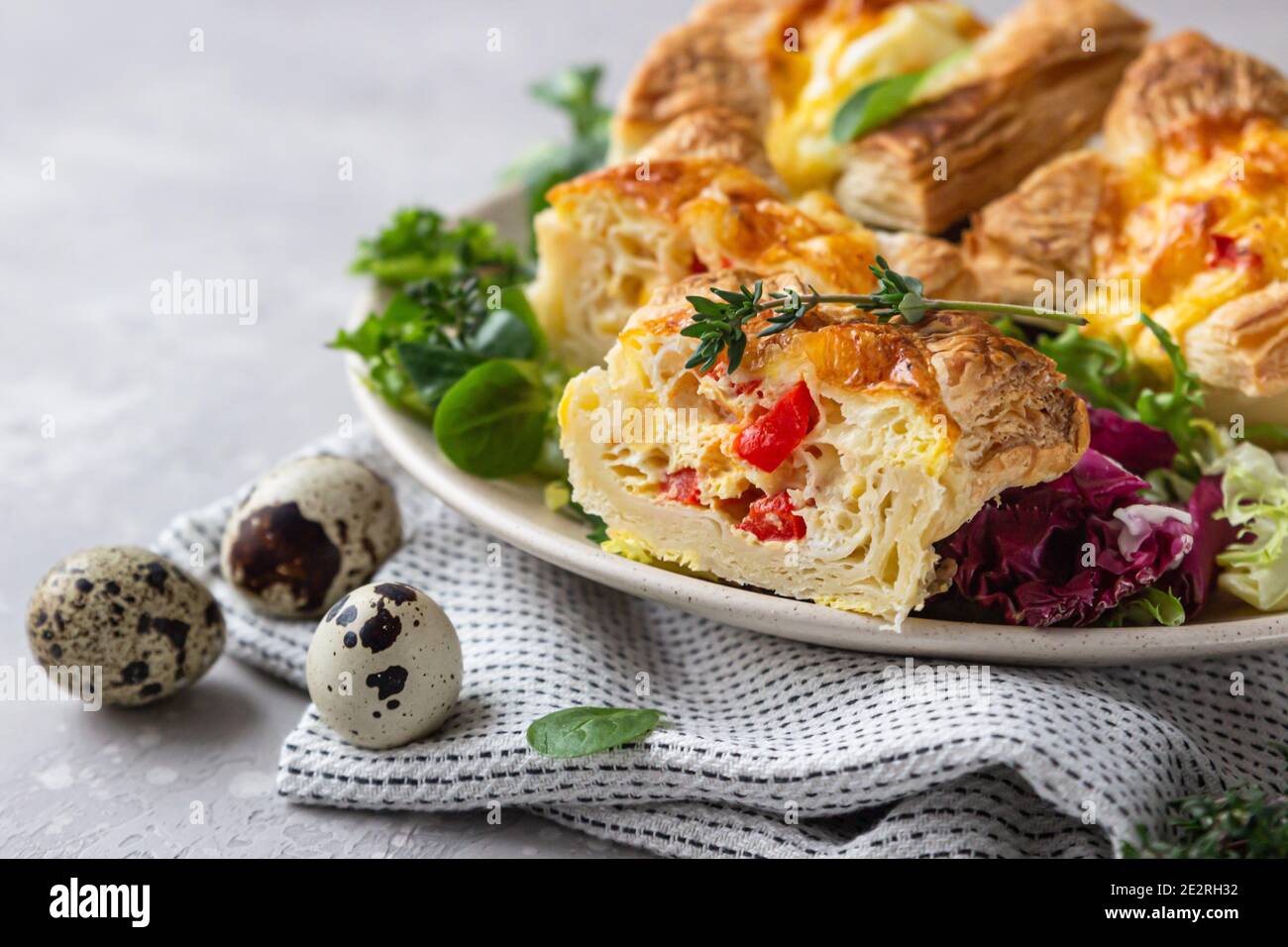 Mini quiche, tarte ou tarte avec légumes servis sur une assiette avec salade verte. Mise au point sélective. Banque D'Images