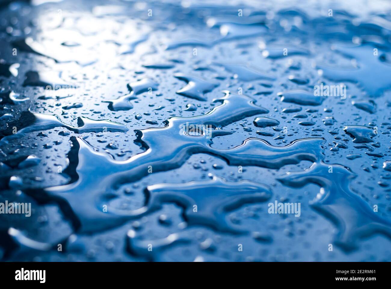 Gouttelettes d'eau sur une surface bleue brillante Banque D'Images