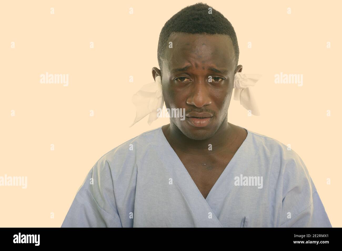 Portrait de jeune homme de l'Afrique noire à la recherche de patients malades avec des tissus dans ses oreilles Banque D'Images