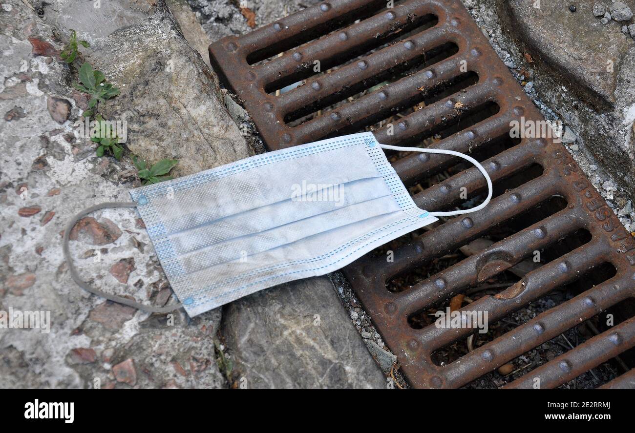 Jeté masque jetable, sur le sol, dans une rue. Chaussée Banque D'Images