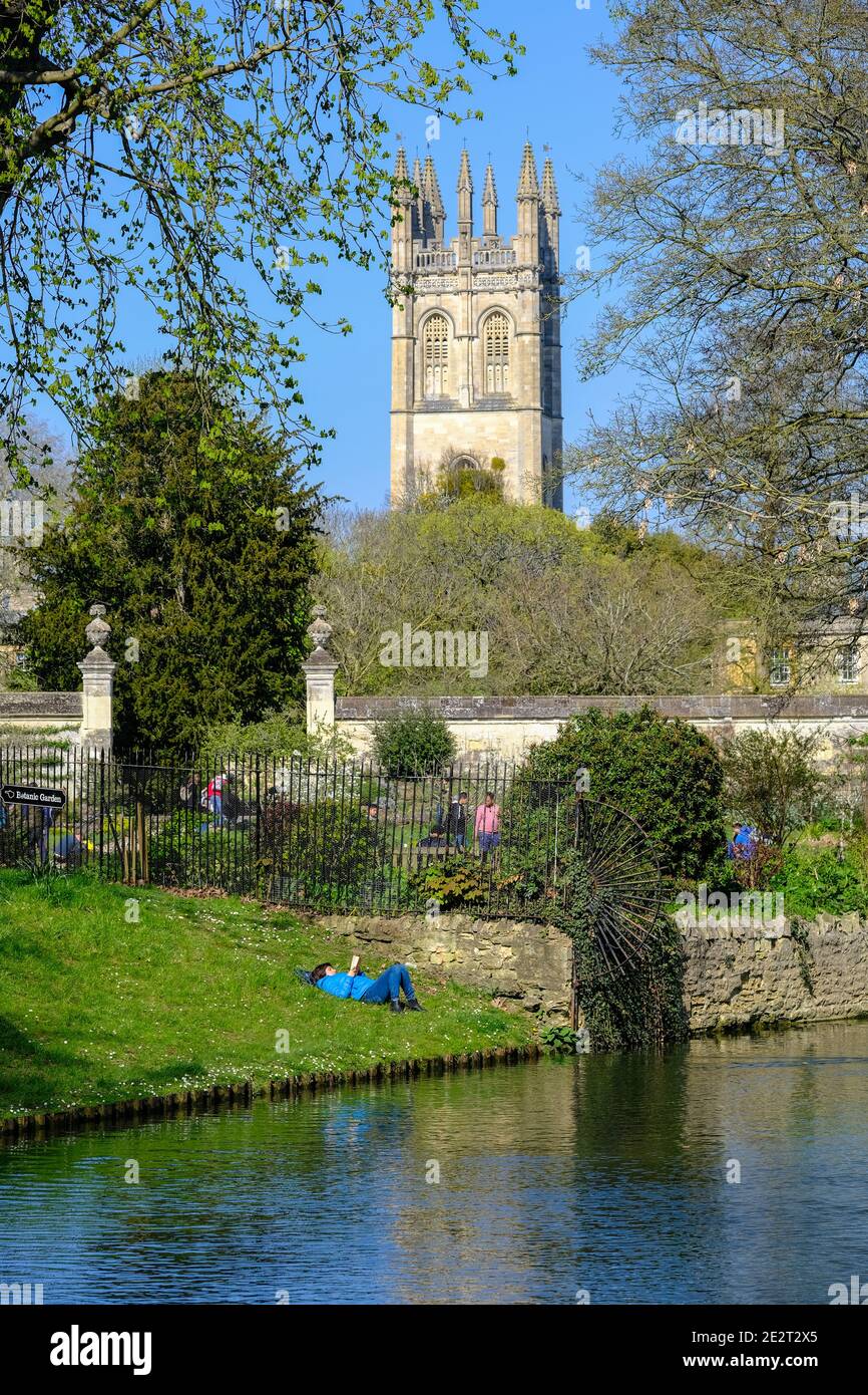 Oxford, Royaume-Uni. Femme lisant un livre du Rover Cherwell avec Merton College Chapel en arrière-plan. Banque D'Images
