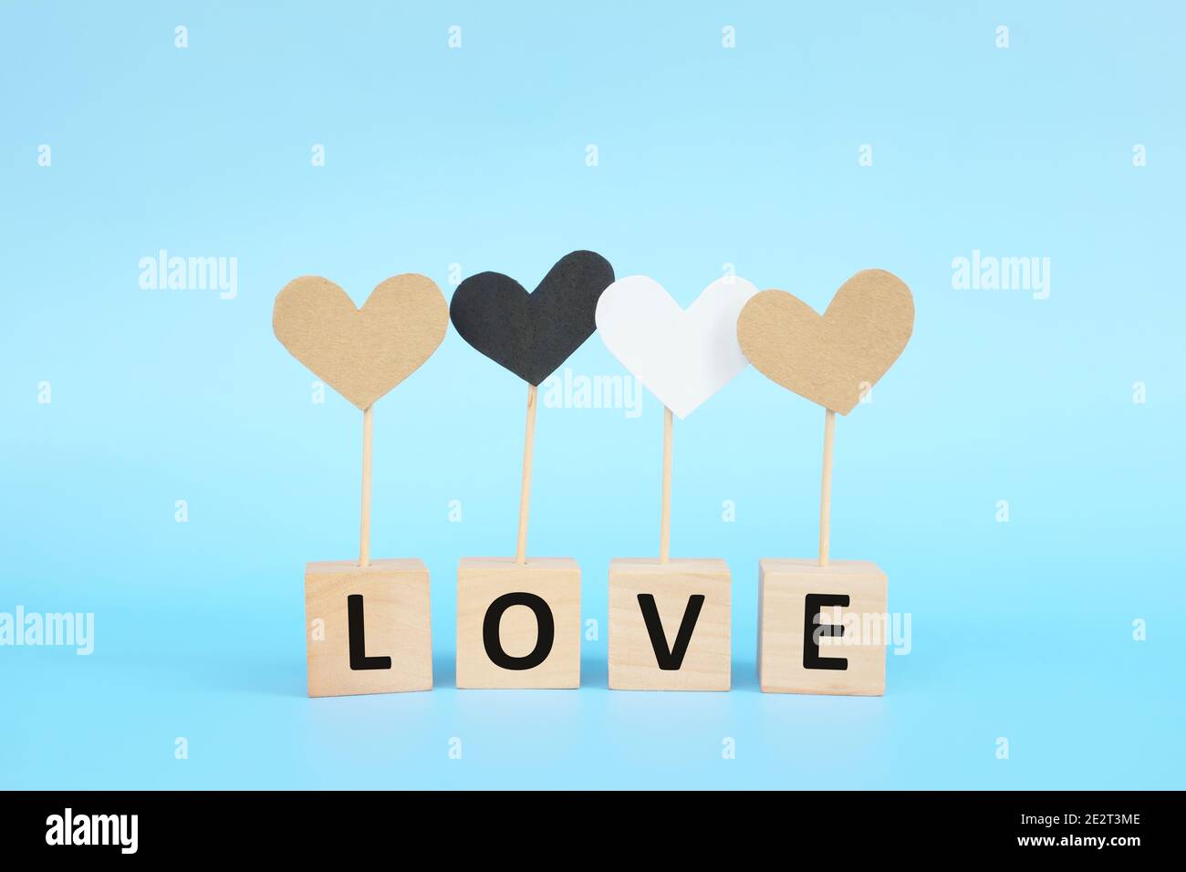 Concept d'égalité raciale, d'inclusion, d'amour et de diversité culturelle. Icône en forme de coeur marron, noir et blanc sur fond bleu. Banque D'Images