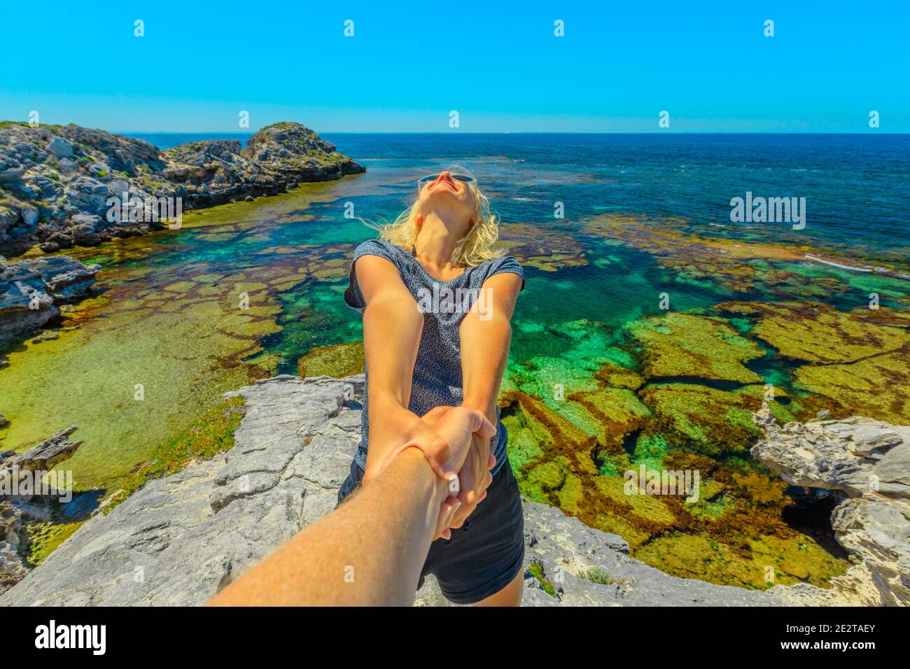 Suivez-moi. Femme blonde tenant la main de son ami de ses à Rottnest Island, Perth, Australie occidentale. Destination tropicale à Jeannies Lookout Banque D'Images