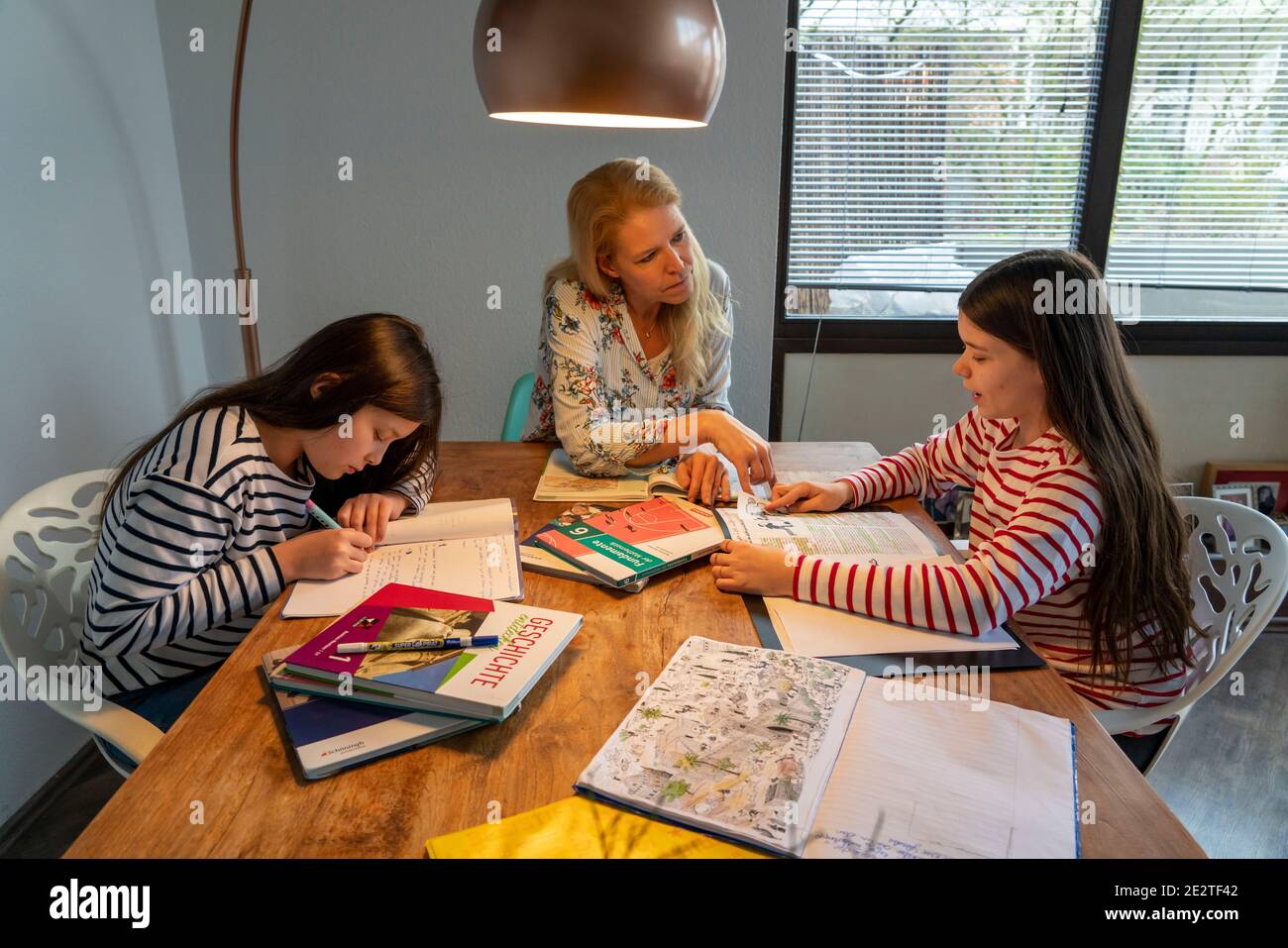 Homeschooling, pendant le confinement en janvier 2021, la mère aide ses deux filles, à la maison, à apprendre, les fermetures d'écoles, l'apprentissage à distance, les effets de Banque D'Images