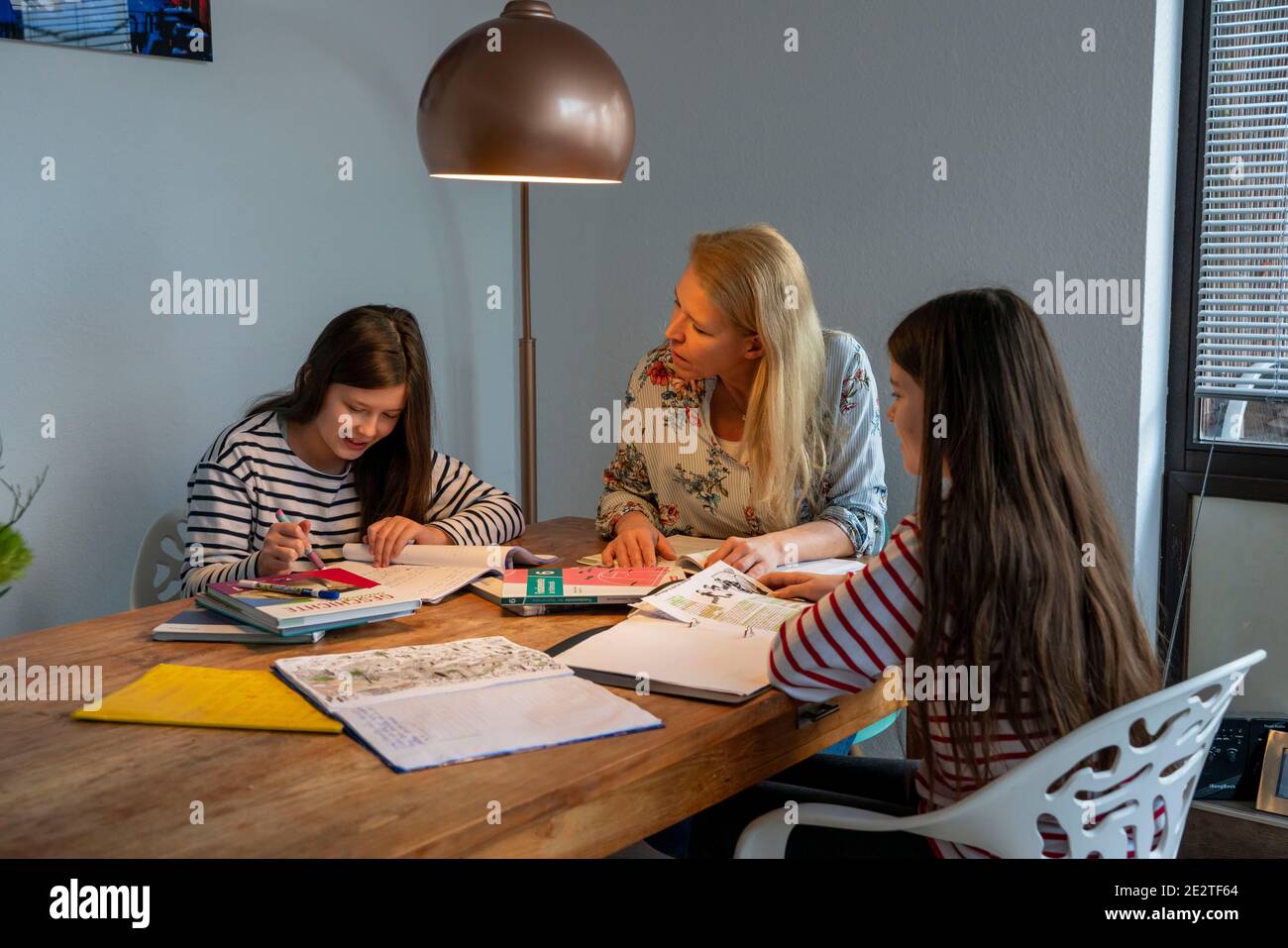 Homeschooling, pendant le confinement en janvier 2021, la mère aide ses deux filles, à la maison, à apprendre, les fermetures d'écoles, l'apprentissage à distance, les effets de Banque D'Images