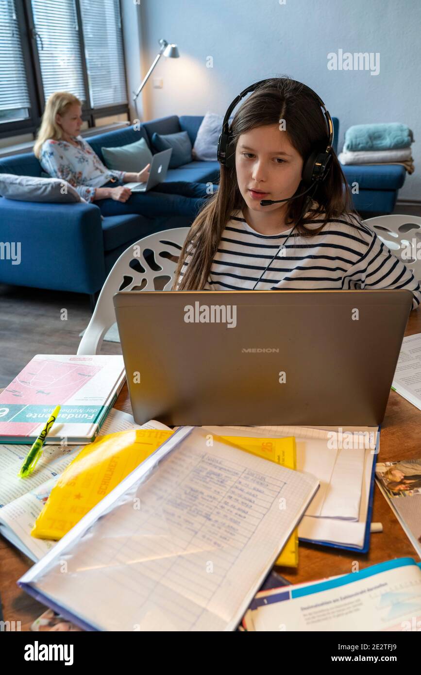 Homeschooling, pendant le verrouillage de janvier 2021, les enfants étudiant à la maison pour l'école, leur mère dans le bureau à domicile travaillant sur l'ordinateur portable avec vide Banque D'Images