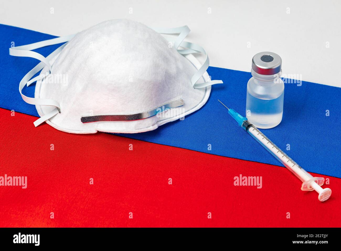 Drapeau russe, masque facial N95, seringue à aiguille et flacon. Concept de distribution du vaccin contre le coronavirus Covid-19, pénurie d'approvisionnement et crise des soins de santé Banque D'Images
