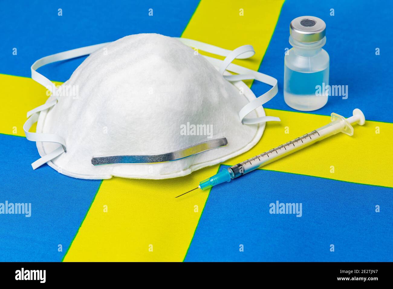 Drapeau suédois, masque facial n95, seringue à aiguille et flacon. Concept de distribution du vaccin contre le coronavirus Covid-19, pénurie d'approvisionnement et crise des soins de santé Banque D'Images