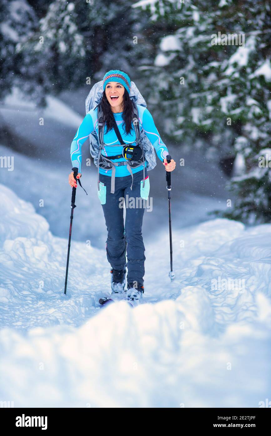 Belle jeune fille pratiquant le ski de randonnée dans les bois Banque D'Images
