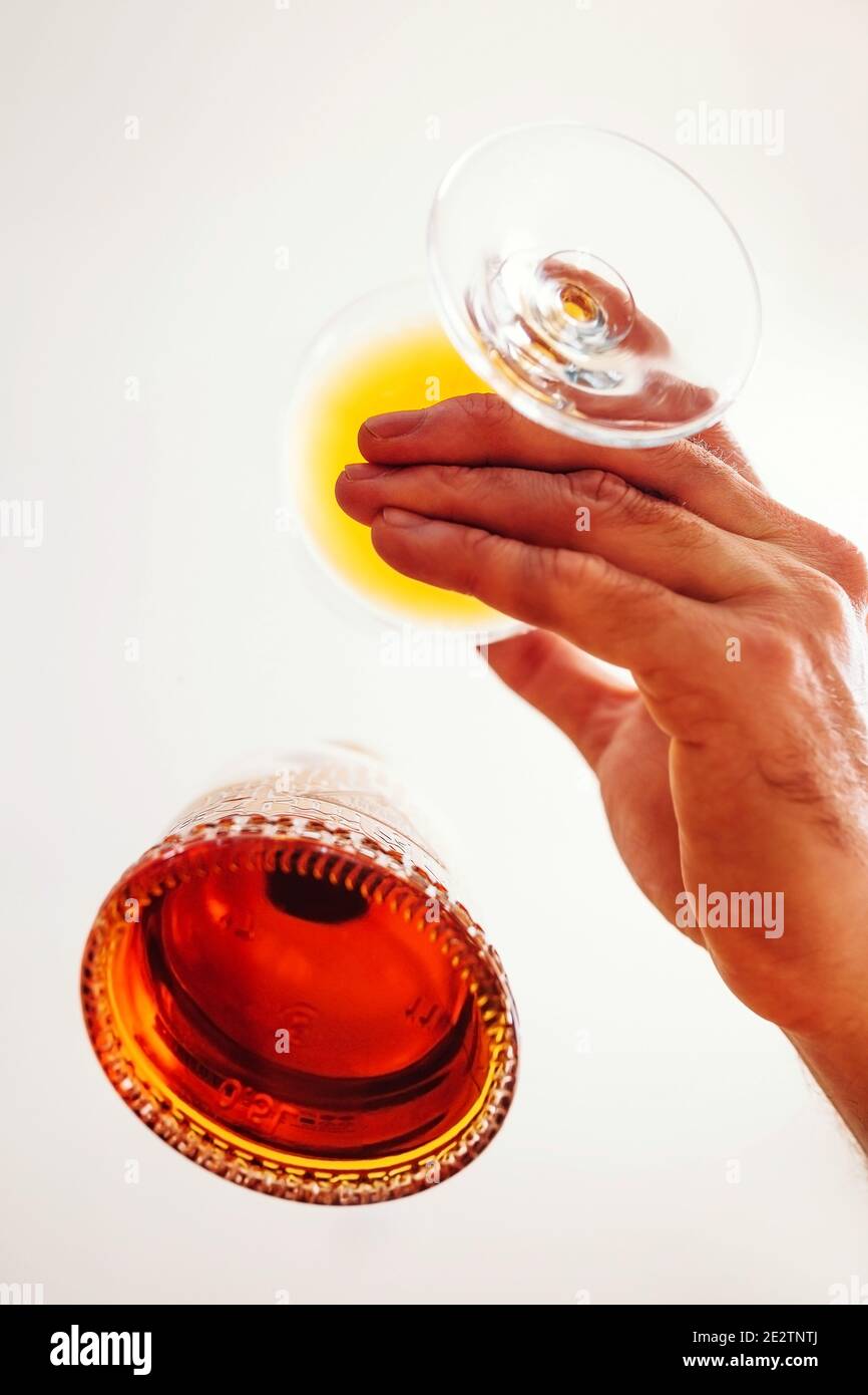 Main masculine avec un verre de brandy près de la bouteille - vue de dessous Banque D'Images