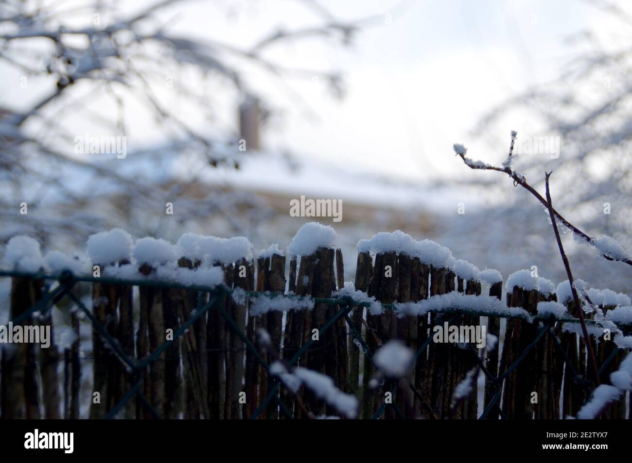 Belle vue de campagne saisonnière. Une couche d'hiver de clôture de couverture blanche et de toit de maison. Banque D'Images