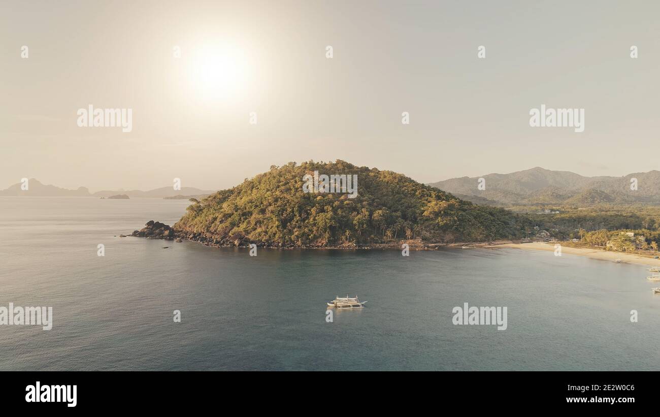 Montagnes vertes au soleil de la baie de mer avec des bateaux aériens. Îlot de paradis tropical à la plage de sable. Navires à passagers et navires sur la côte océanique. Vacances d'été à El Nido Island, Philippines, Asie Banque D'Images