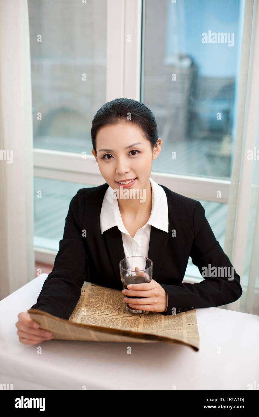 Jeune femme d'affaires tenant un journal à son bureau photo de haute qualité Banque D'Images