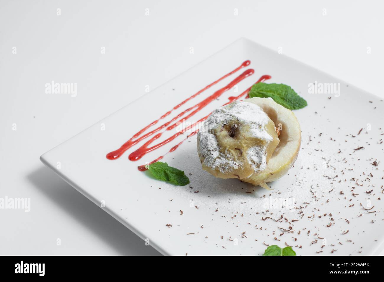 pomme savoureuse cuite avec noix, sirop et menthe sur l'assiette isolée Banque D'Images