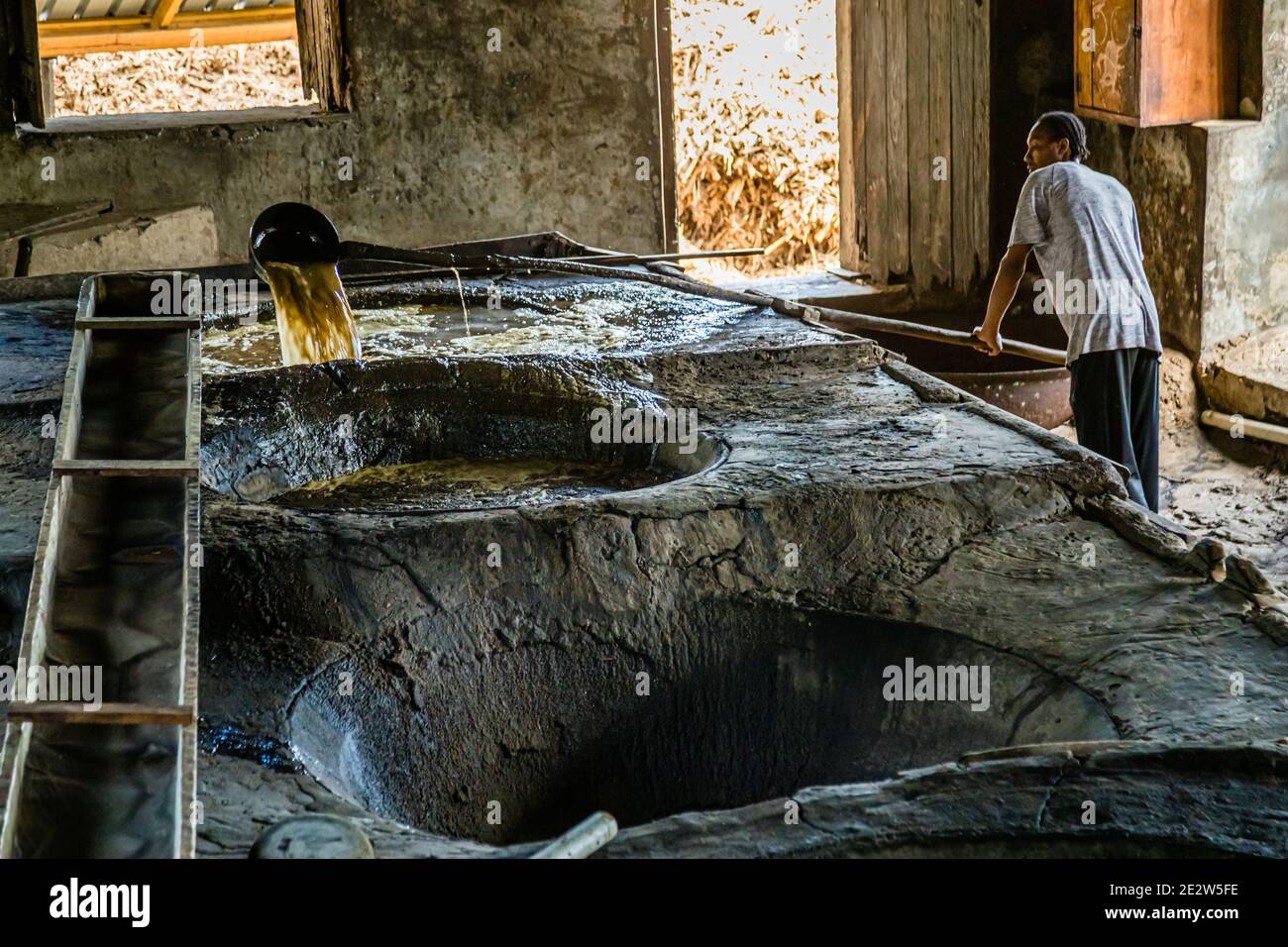 Des murs de briques et un sol en pierre mouillé caractérisent l'intérieur de la distillerie de rhum Antoine Rivers à La Poterie, Saint Patrick, Grenade. Banque D'Images