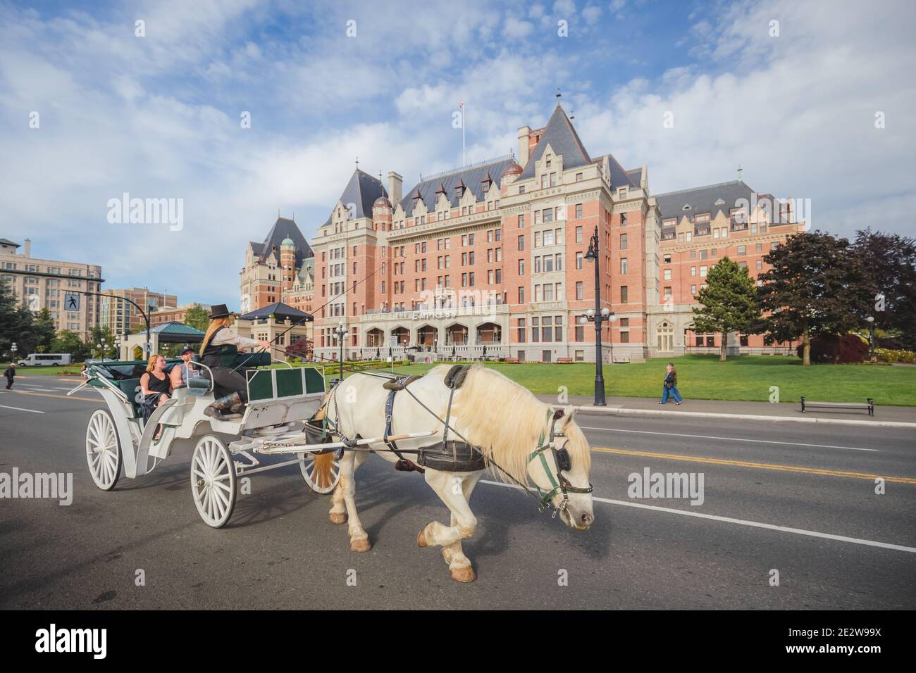Victoria, Canada - juin 6 2017 : les touristes profitent d'une promenade en calèche en face de l'hôtel Fairmont Empress, le long du port intérieur de Victo Banque D'Images
