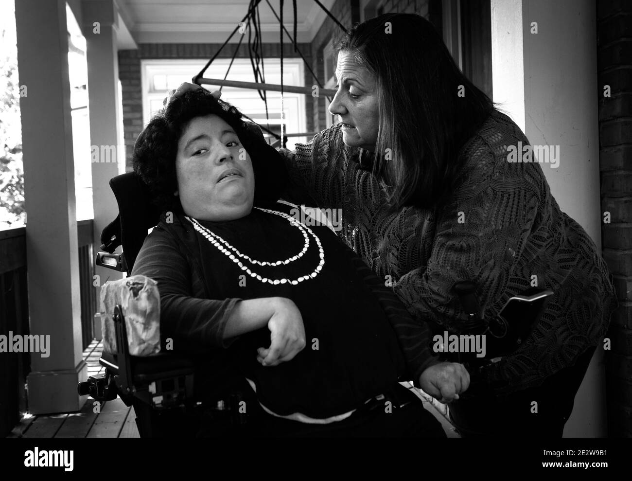 Atlanta, Géorgie, États-Unis. 15 janvier 2021. Gabby Dollar, 31 ans, et sa mère Shelly aiment l'air frais sur le porche de leur maison d'Atlanta où Gabby vit maintenant. Gabby, qui est né avec la paralysie cérébrale et l'autisme, canÃt marcher ou parler mais comprend ce que les autres disent. Elle vivait dans sa propre maison avec 24/7 soutiens, mais elle devait retourner vivre avec ses parents lorsque la pandémie de Covid est apparue et la placer à un plus grand risque d'infection. Aujourd’hui, ils attendent le résultat des négociations avec les responsables du Medicaid et les législateurs de l’État, qui se débattent avec les propositions de révision budgétaire qui réduisent le soutien à Gabby et à 187 ind Banque D'Images