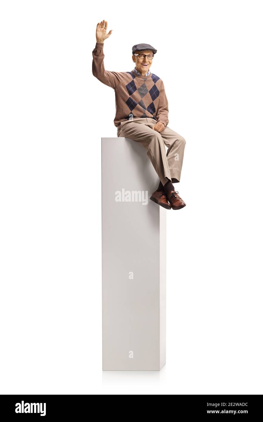 Homme âgé assis sur une colonne et agitant à la caméra isolé sur fond blanc Banque D'Images