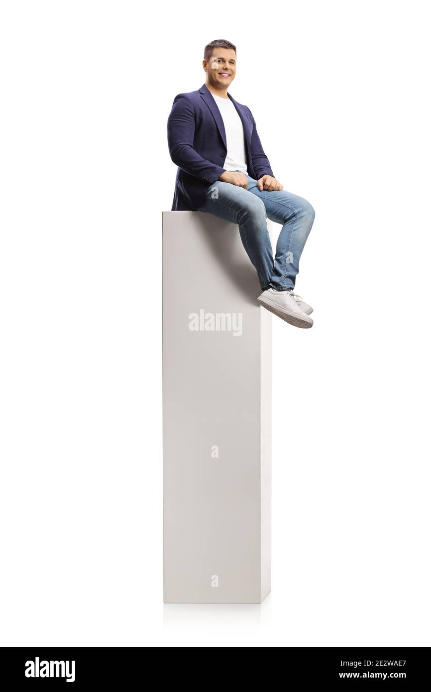 Jeune homme professionnel assis sur une haute colonne blanche isolée sur fond blanc Banque D'Images