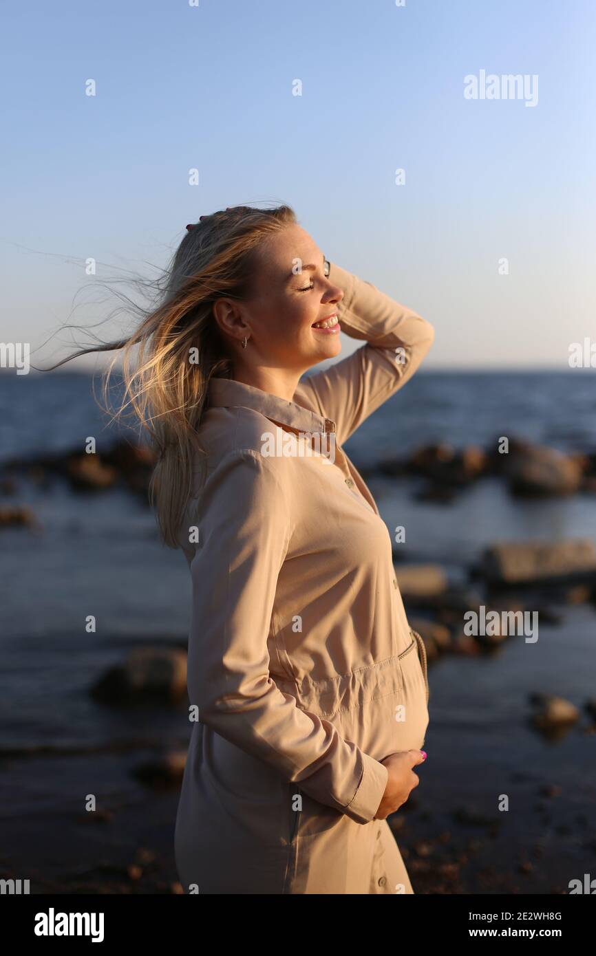 Bonne femme enceinte près de la mer en été. Banque D'Images